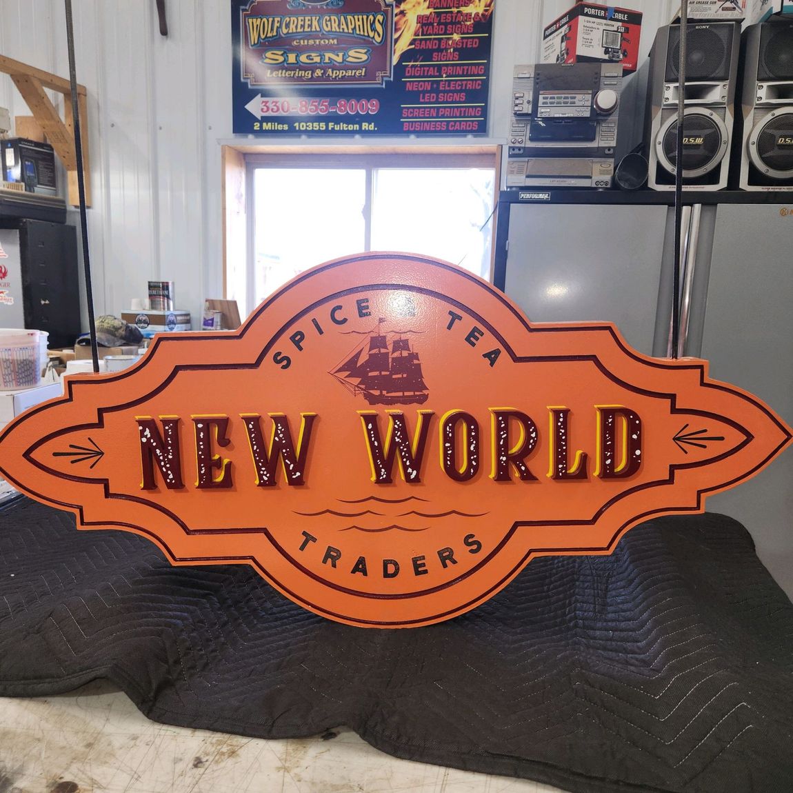 Custom carved sign for New World Spice Tea Traders made by Wolf Creek Graphics
